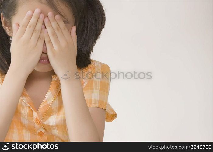 Close-up of a girl crying and hiding her face