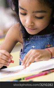Close-up of a girl drawing in a coloring book