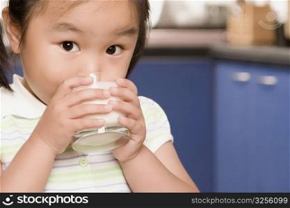 Close-up of a girl drinking milk from a glass