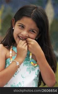 Close-up of a girl eating a candy necklace