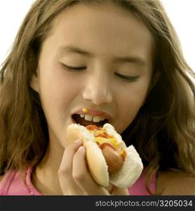 Close-up of a girl eating a hot dog