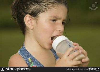 Close-up of a girl holding a baby bottle