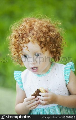 Close-up of a girl holding a biscuit