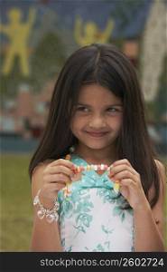 Close-up of a girl holding a candy necklace