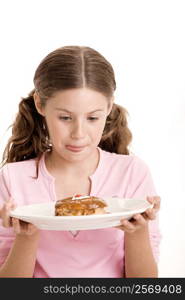 Close-up of a girl holding a donut in a plate licking her lips