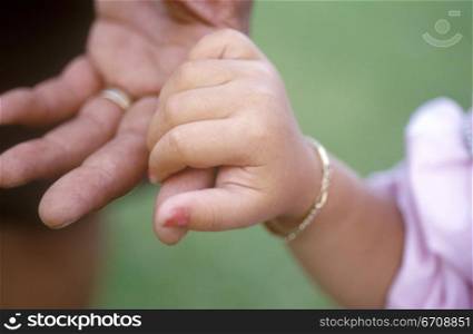 Close-up of a girl holding a person&acute;s finger