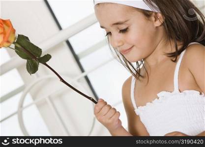 Close-up of a girl holding a rose and smiling