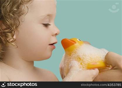 Close-up of a girl holding a rubber duck and smiling