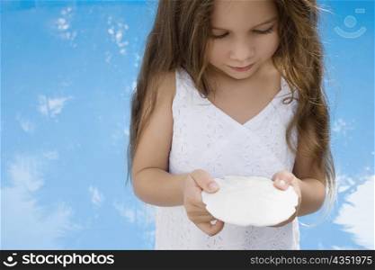 Close-up of a girl holding a seashell