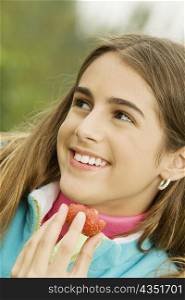 Close-up of a girl holding a strawberry