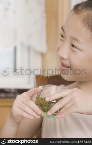 Close-up of a girl holding a tea cup and smiling