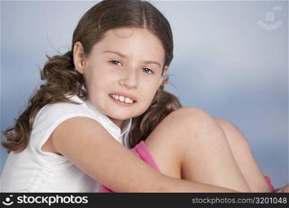 Close-up of a girl hugging her knees