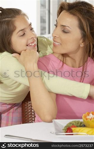 Close-up of a girl hugging her mother