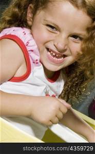 Close-up of a girl in a toy car and smiling