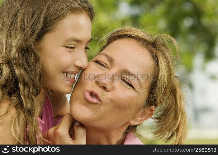 Close-up of a girl kissing her mother