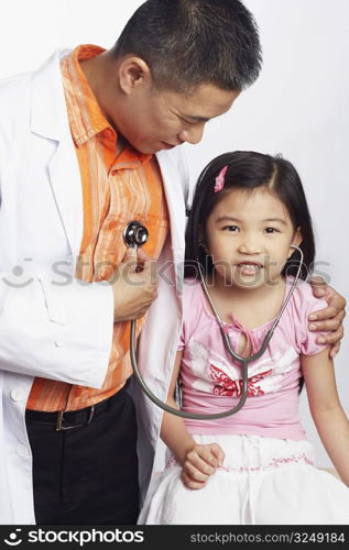 Close-up of a girl listening to a male doctors heart beat with a stethoscope