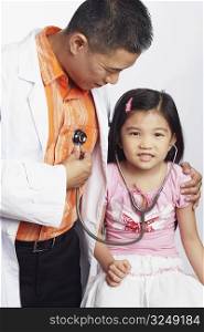 Close-up of a girl listening to a male doctors heart beat with a stethoscope