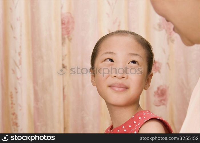 Close-up of a girl looking at her grandmother and smiling