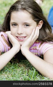 Close-up of a girl lying on the grass and smiling