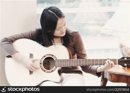 Close-up of a girl playing the guitar