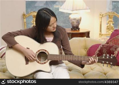 Close-up of a girl playing the guitar