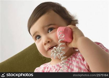 Close-up of a girl playing with a toy phone