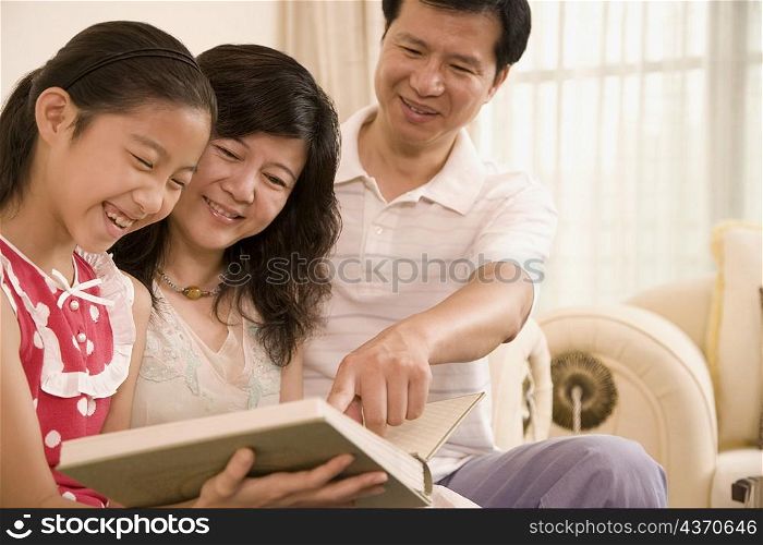 Close-up of a girl reading a book with her parents