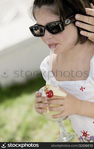 Close-up of a girl sipping drink from a glass