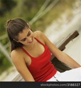 Close-up of a girl sitting on a bench at the beach