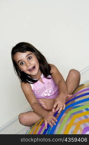 Close-up of a girl sitting on a large inflatable ball