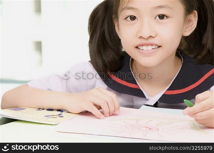 Close-up of a girl smiling and holding a colored pencil