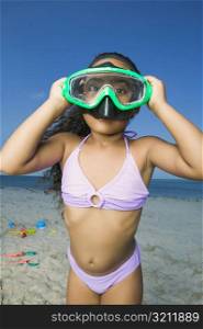 Close-up of a girl standing on the beach and wearing a scuba mask