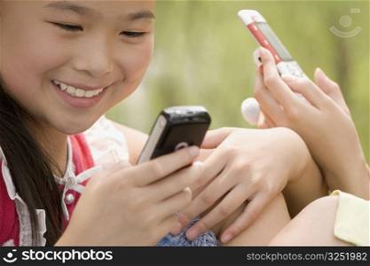 Close-up of a girl using a mobile phone and smiling