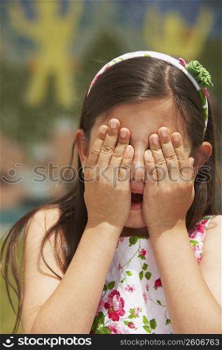 Close-up of a girl with her hand covering her eyes