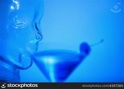 Close-up of a glass mannequin drinking a glass of martini