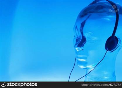 Close-up of a glass mannequin wearing headphones