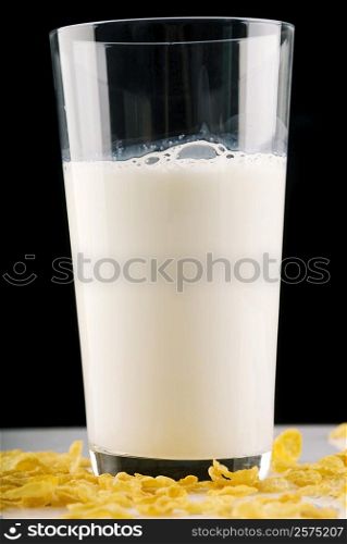 Close-up of a glass of milk with corn flakes