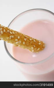 Close-up of a glass of milkshake with a breadstick
