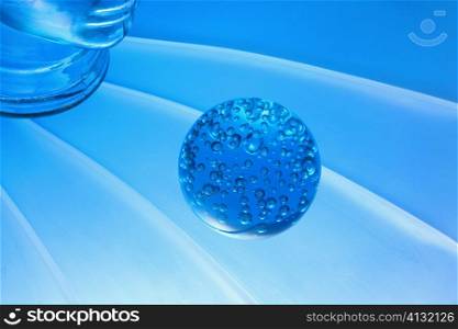 Close-up of a glass paperweight in front of a glass mannequin