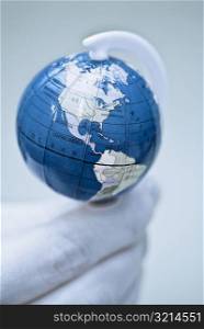 Close-up of a globe on a human finger