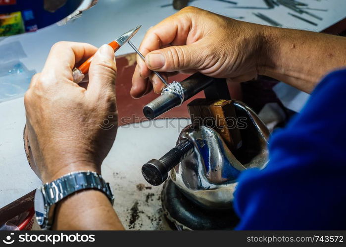 Close up of a goldsmith's hand making silver ring.