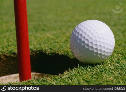 Close-up of a golf ball at the edge of hole
