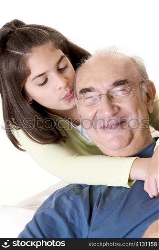 Close-up of a granddaughter hugging her grandfather from behind