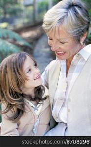 Close-up of a grandmother and her granddaughter smiling