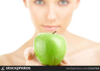 Close up of a green apple against a woman&acute;s face, isolated