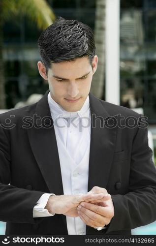 Close-up of a groom adjusting his wedding ring
