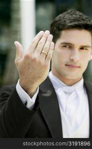 Close-up of a groom showing his wedding ring