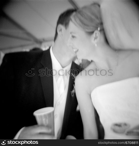 Close-up of a groom whispering to his bride