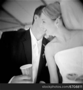 Close-up of a groom whispering to his bride