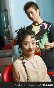 Close-up of a hairdresser adjusting a young woman&acute;s hair